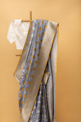 Gray pure benarasi silk handwoven saree with fun floral bootas in silver and bronze zari and a mustard kanni by Roliana Weaves. Best Banarasi Sarees online