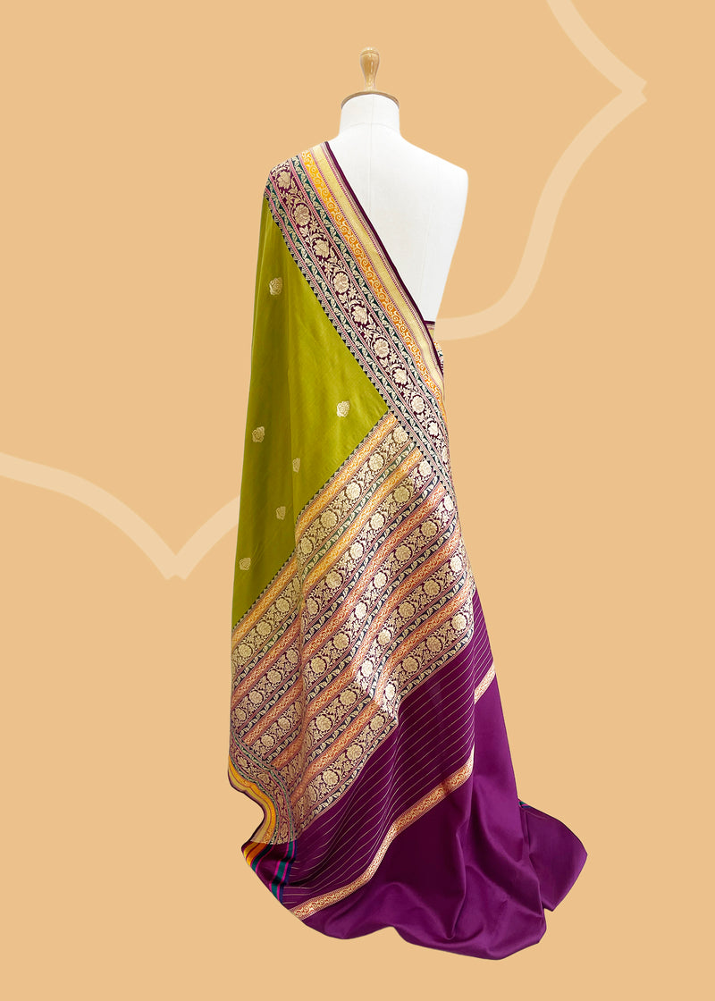 An olive green gajji silk saree with delicate bootis all over and a beautiful contrasting border with jewel toned colours of purple emerald and ochre shades. Shop the best collection of authentic, handwoven, pure benarasi sarees with Roliana New Delhi