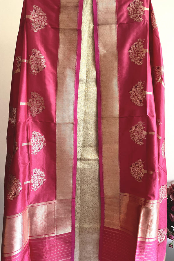 A coral coloured banarasi silk dupatta with tree of life motifs woven all over with delicate meenakari work and a gold border by Roliana Weaves.