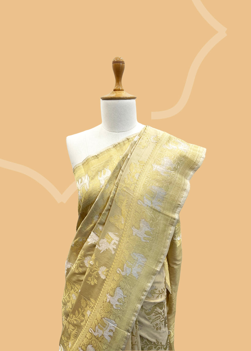 A classic cream and gold Shikargah weave pure Banarasi ssaree. Shop the best collection of authentic, handwoven, pure benarasi sarees with Roliana New Delhi