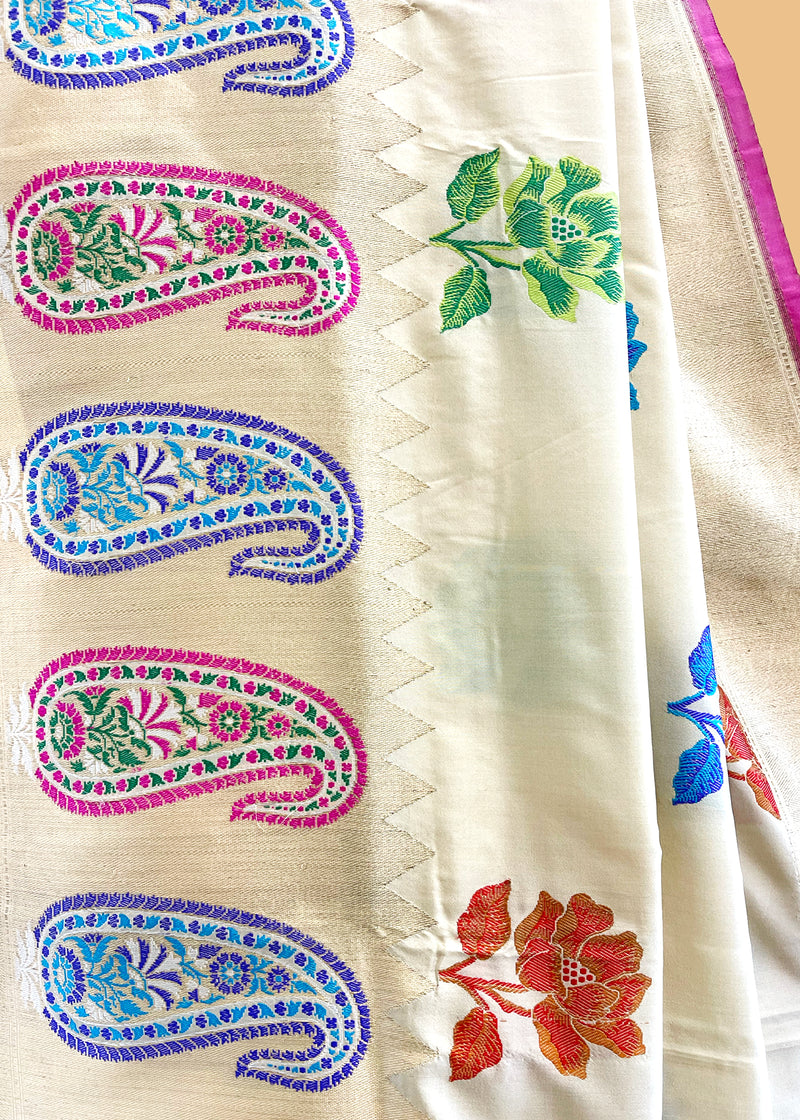 An beautiful mix of flowers and paisley motifs woven with meenakari work in a badami cream colour silk saree. Shop the best collection of authentic, handwoven, pure benarasi sarees with Roliana New Delhi