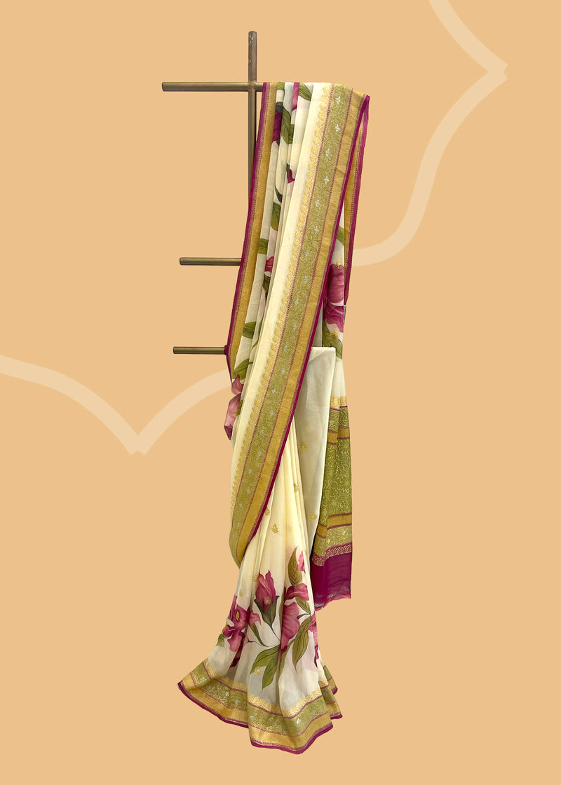  ivory cream saree in Georgette with zari bootis and border and hand painted irises in wine colour all over the saree.. A pure Banarasi wedding Sari Shop the best collection of authentic, handwoven, pure benarasi sarees with Roliana New Delhi