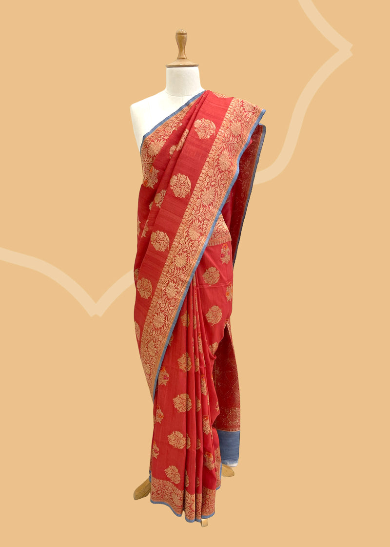 A Ruby Red tussar Georgette saree with gold zari booties and pallu border and a contrast gray kanni and blouse. A pure Banarasi Sari Shop the best collection of authentic, handwoven, pure benarasi sarees with Roliana New Delhi