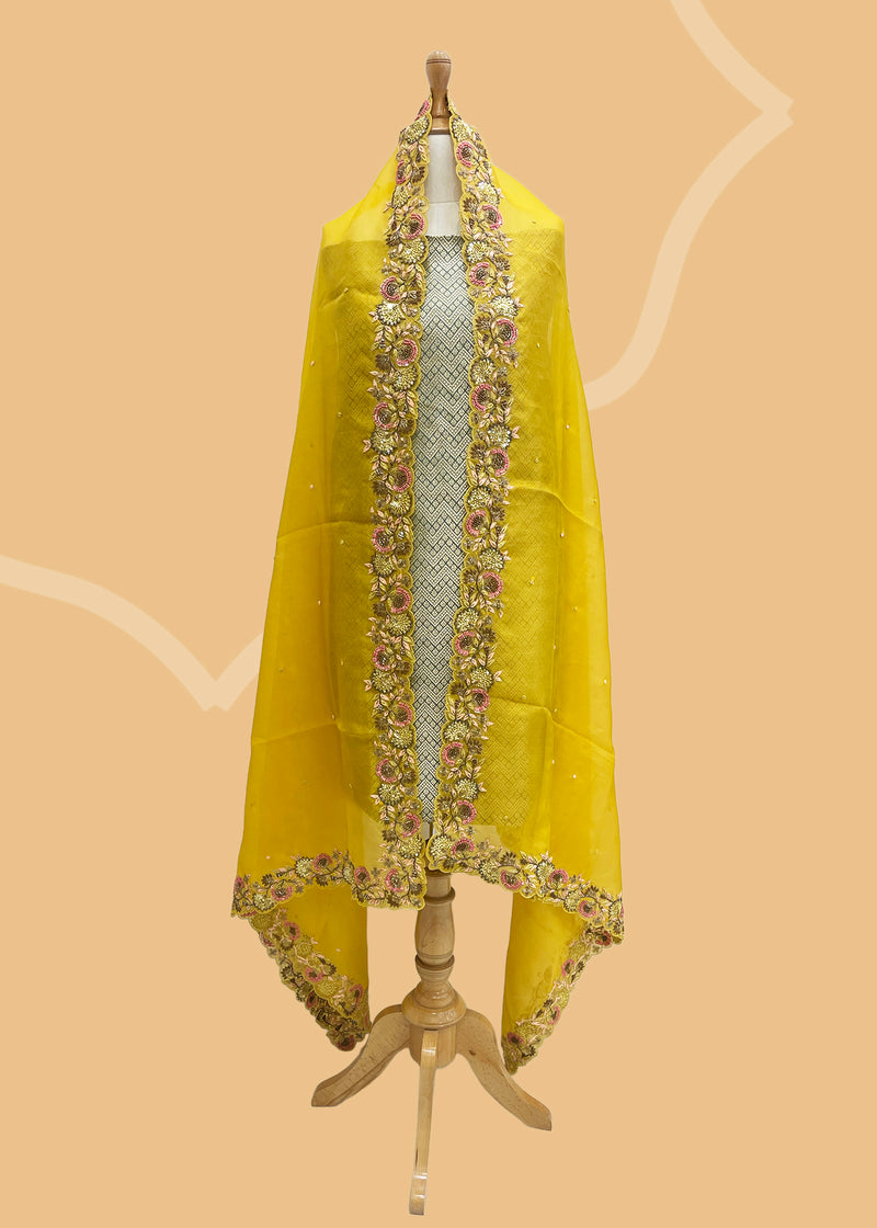 A lemon yellow organza dupatta with marodi work by Roliana Weaves. Shop the best of Banarasi sarees, dupattas and lehengas at Roliana New Delhi