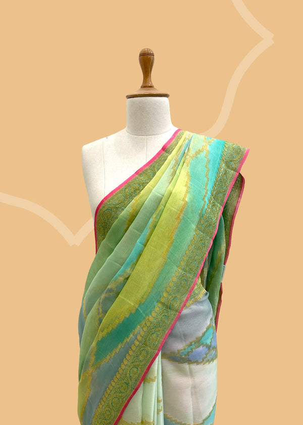 A Georgette saree in abstract weave in shades of sea green and blue with a soft pink kanni and blouse. A pure Banarasi wedding Sari Shop the best collection of authentic, handwoven, pure benarasi sarees with Roliana New Delhi
