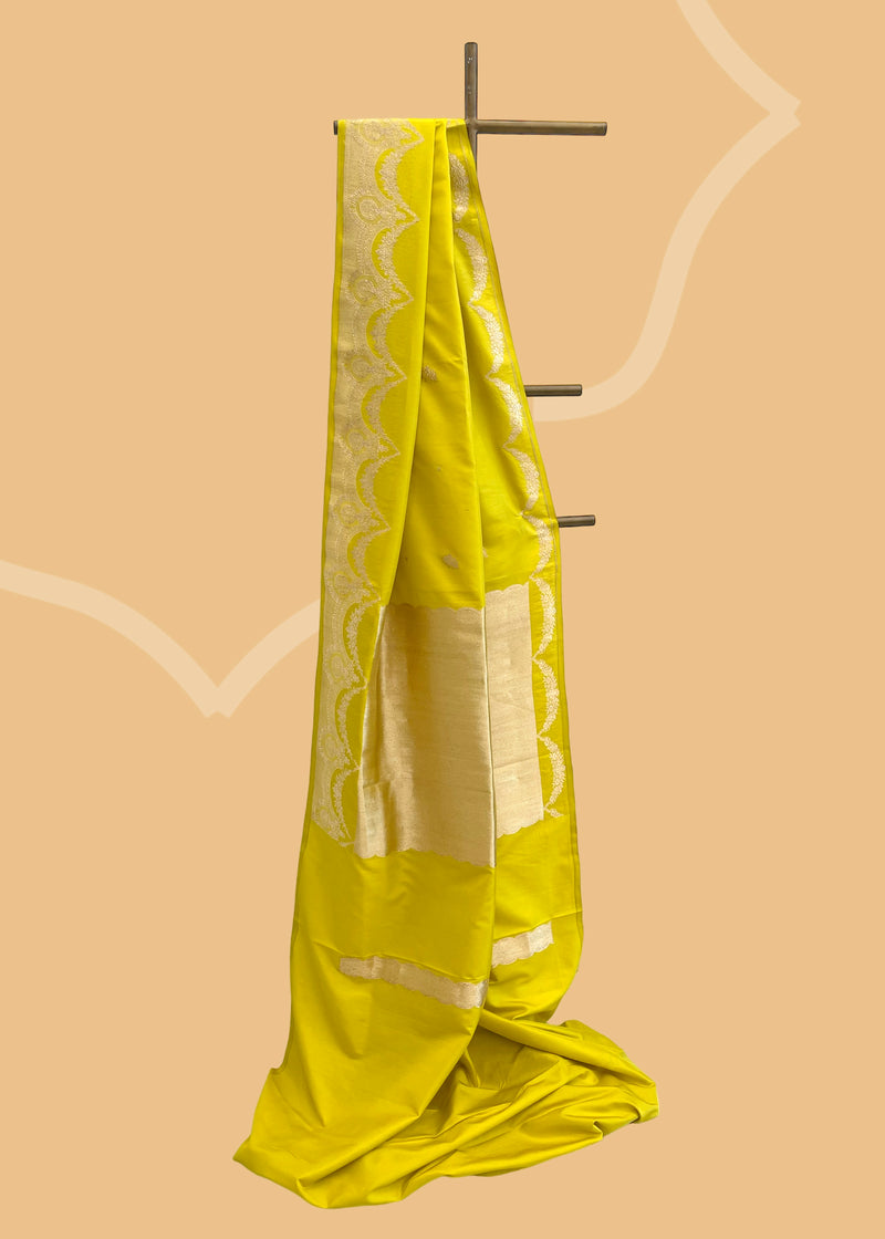 A lime  green  soft silk saree with small zari bootis all over and a beautiful trellis border with scallops and flowers.. A pure Banarasi Sari Shop the best collection of authentic, handwoven, pure benarasi sarees with Roliana New Delhi