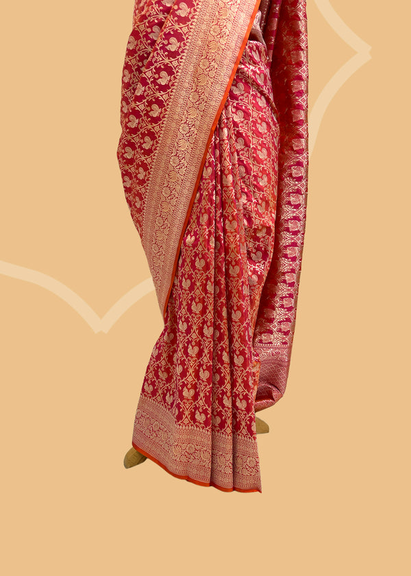 A silk brocade morwali saree in peach and pink shot colour completed with and elegant floral border and pallu. Shop the best collection of authentic, handwoven, pure benarasi sarees with Roliana New Delhi