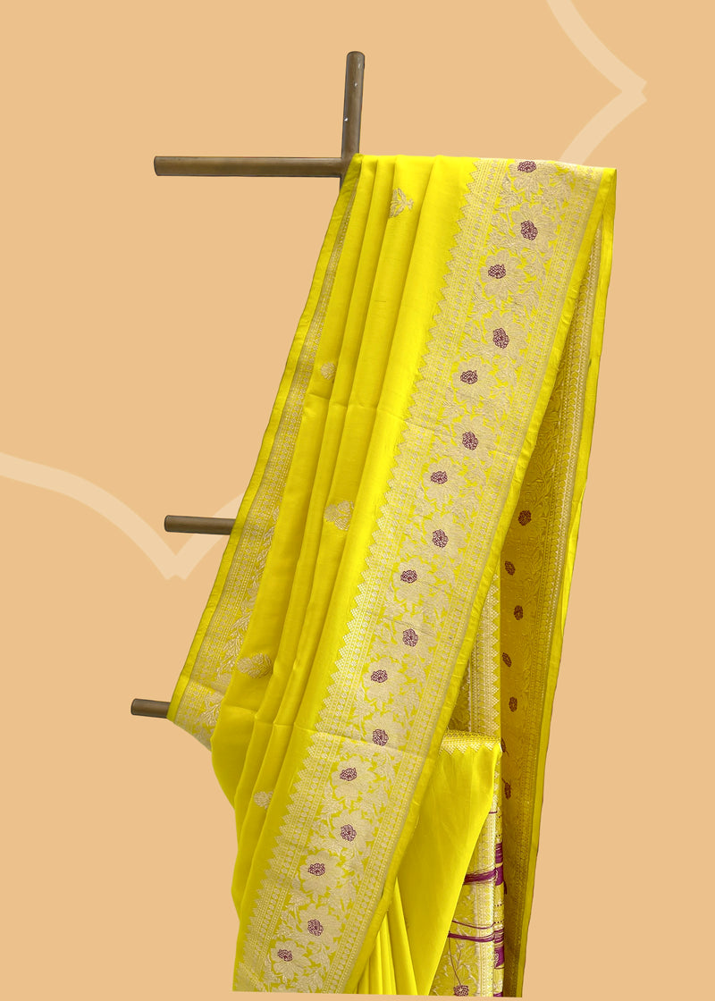 A fresh mustard yellow saree with delicate woven flowers and border in contrast meenakari colours. A pure Banarasi Sari Shop the best collection of authentic, handwoven, pure benarasi sarees with Roliana New Delhi