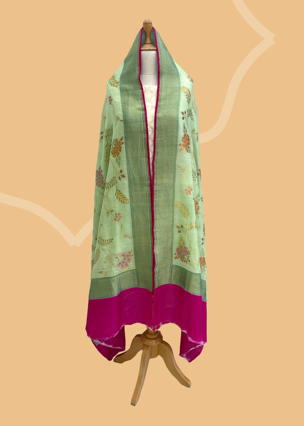 A pista green dupatta with a floral hand painted and hand woven jaal and a vibrant pink kanni. Shop the best of Banarasi sarees, dupattas and lehengas at Roliana New Delhi