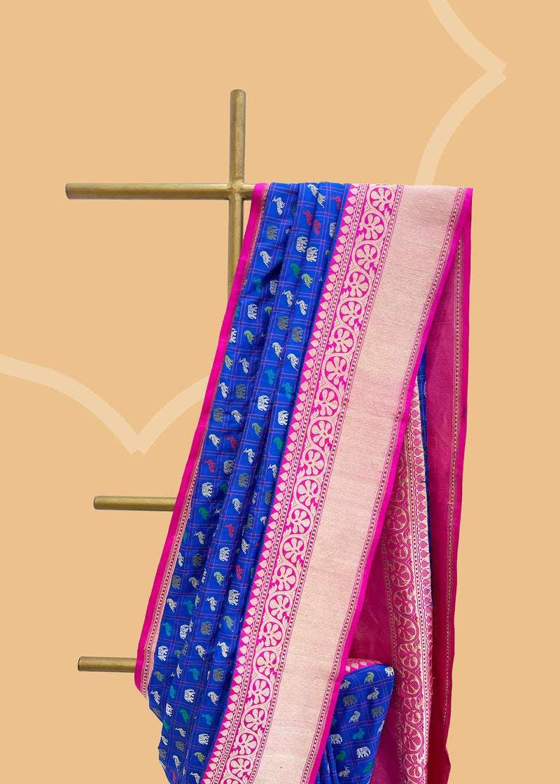 Royal blue woven checks saree with zari shikargah bootis and a contrast Rani pink border and pallu in soft silk. Shop the best collection of authentic, handwoven, pure benarasi sarees with Roliana New Delhi
