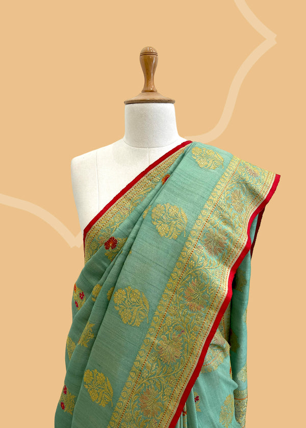A patina green tussar Georgette saree with cluster bouquets in meenakari floral bootas and hand painted. A pure Banarasi Sari Shop the best collection of authentic, handwoven, pure benarasi sarees with Roliana New Delhi