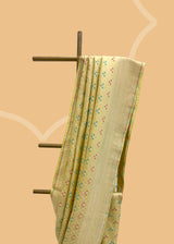 A cream yellow silk saree with brocade pyramid weave interspersed with pale yellow and firozi detailed flowers and a geometric pallu and border. A pure Banarasi wedding Sari Shop the best collection of authentic, handwoven, pure benarasi sarees with Roliana New Delhi