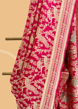 A Rani pink gajji saree with peacocks all over with a sage green meenakari detail and an underlying floral jaal and border. Shop the best collection of authentic, handwoven, pure benarasi sarees with Roliana New Delhi