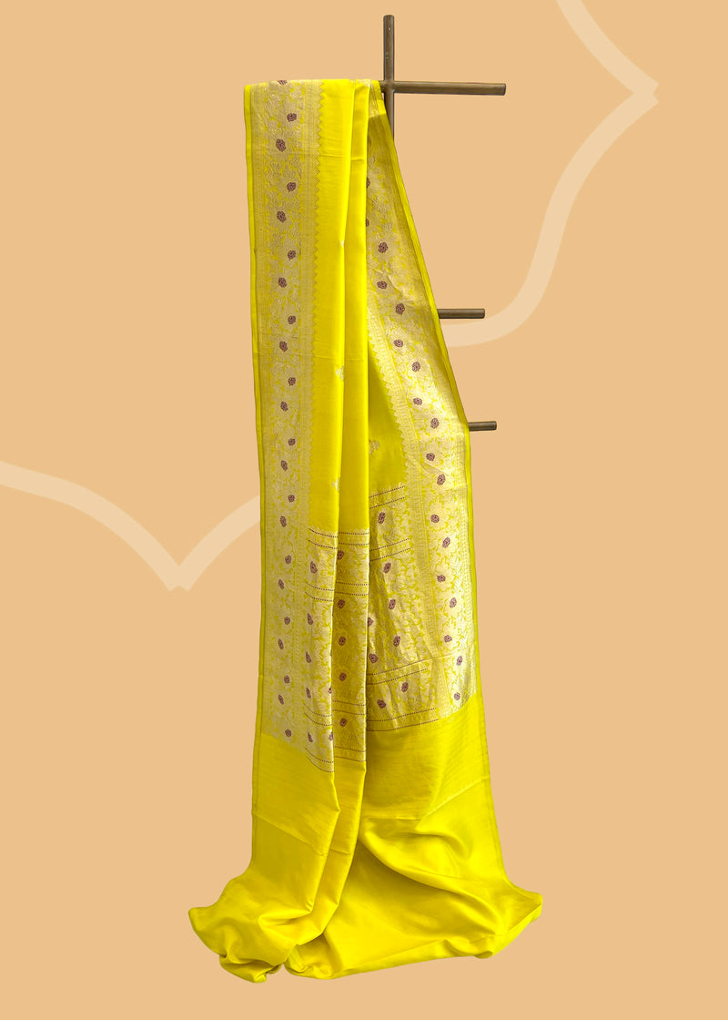 A fresh mustard yellow saree with delicate woven flowers and border in contrast meenakari colours. A pure Banarasi Sari Shop the best collection of authentic, handwoven, pure benarasi sarees with Roliana New Delhi