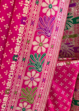 An elegant silk saree in a beautiful Rani pink colour with small bootis all over and a beautiful floral meenakari pallu and border