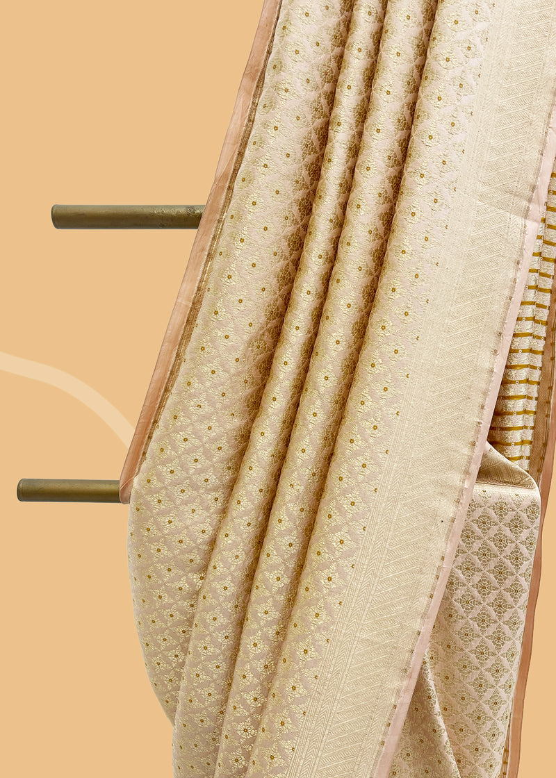 A soft peach brocade saree with meenakari details and a thos zari border. Shop the best collection of authentic, handwoven, pure benarasi sarees with Roliana New Delhi