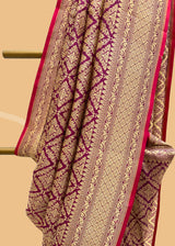 A wine coloured silk brocade saree with barfi weave in zari and a contrast maroon kanni pure Banarasi Sari Shop the best collection of authentic, handwoven, pure benarasi sarees with Roliana New Delhi