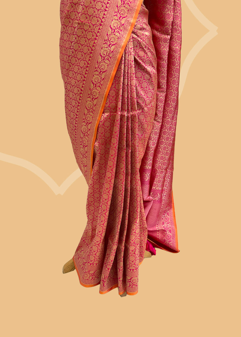 Pink silk saree in floral brocade weave with all over motifs and ornamental pallu with a delightful orange contrast kanni. pure Banarasi sari. Shop the best collection of authentic, handwoven, pure benarasi sarees with Roliana New Delhi