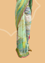 A Georgette saree in abstract weave in shades of sea green and blue with a soft pink kanni and blouse. A pure Banarasi wedding Sari Shop the best collection of authentic, handwoven, pure benarasi sarees with Roliana New Delhi