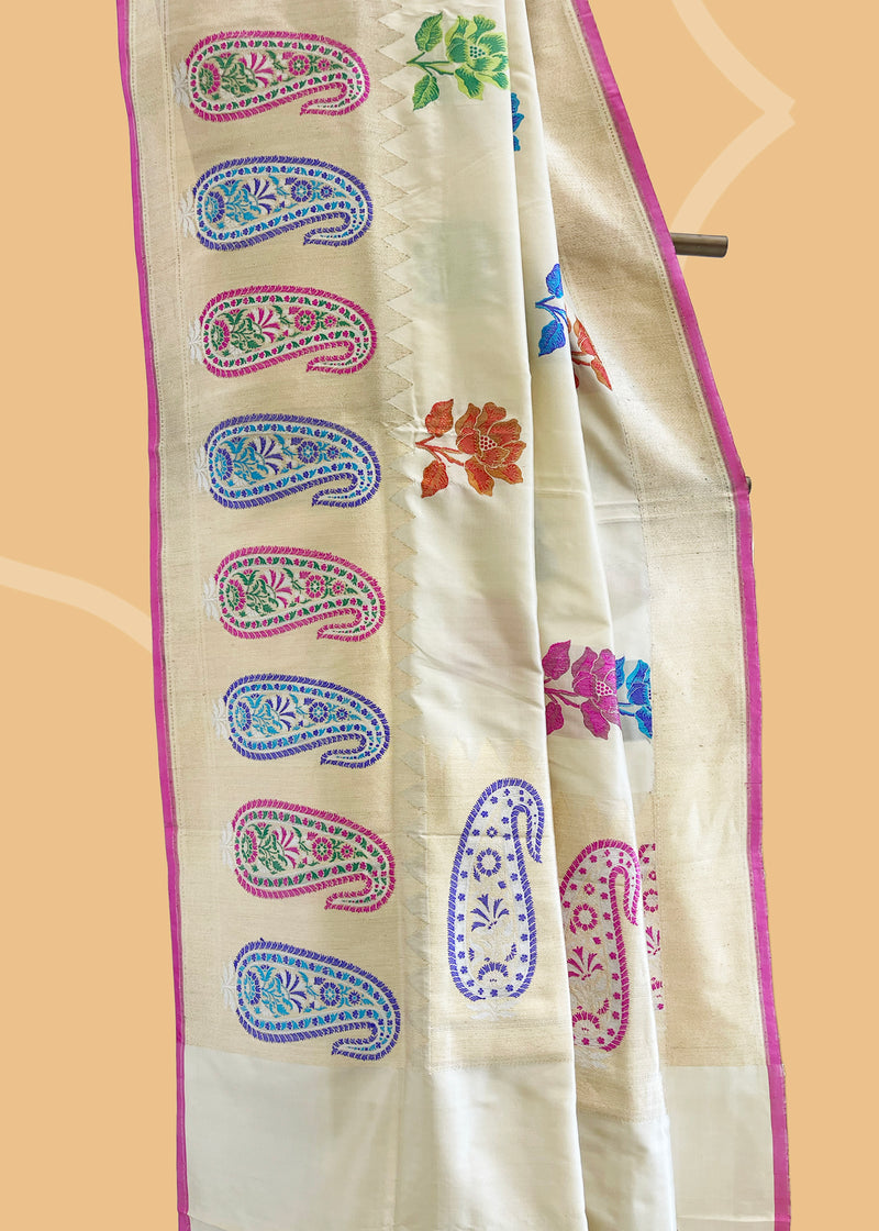An beautiful mix of flowers and paisley motifs woven with meenakari work in a badami cream colour silk saree. Shop the best collection of authentic, handwoven, pure benarasi sarees with Roliana New Delhi