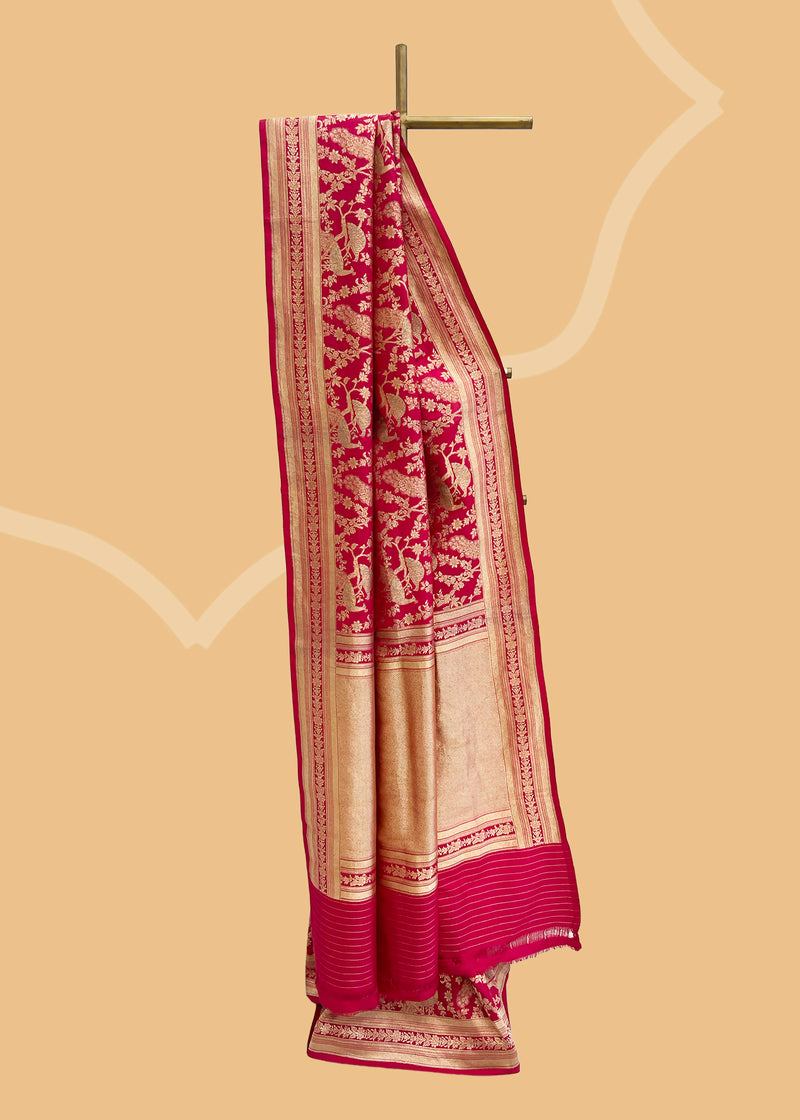 A Rani pink gajji saree with peacocks all over with a sage green meenakari detail and an underlying floral jaal and border. Shop the best collection of authentic, handwoven, pure benarasi sarees with Roliana New Delhi